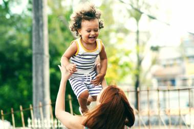 woman playing with happy child