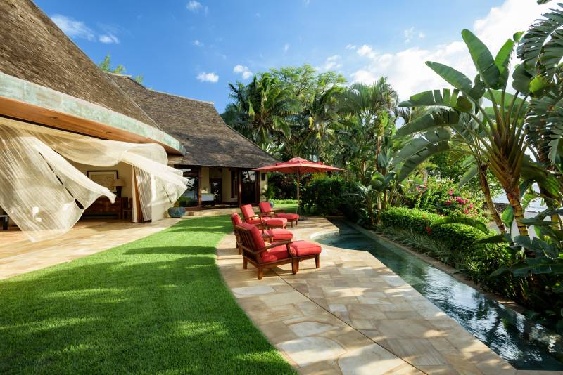 lounge chairs sit outside balinese inspired home on maui