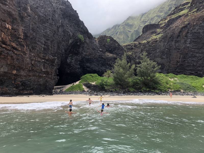 kids running in ocean on kauai beach
