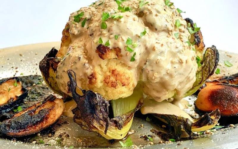 roasted cauliflower topped with tahini sauce for thanksgiving