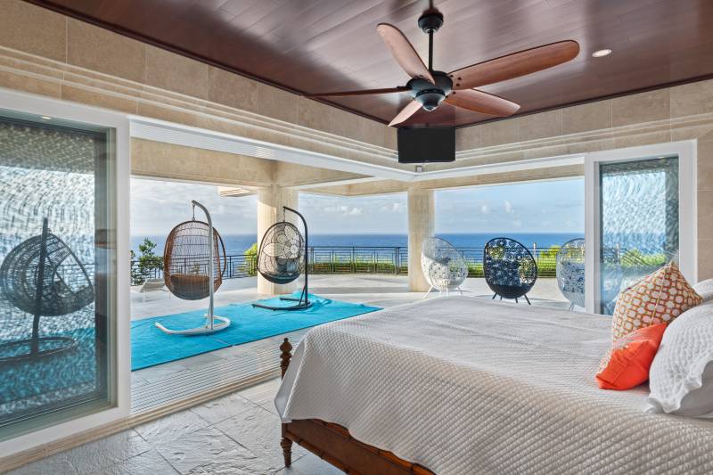 large sliding doors open in bedroom look out to ocean views