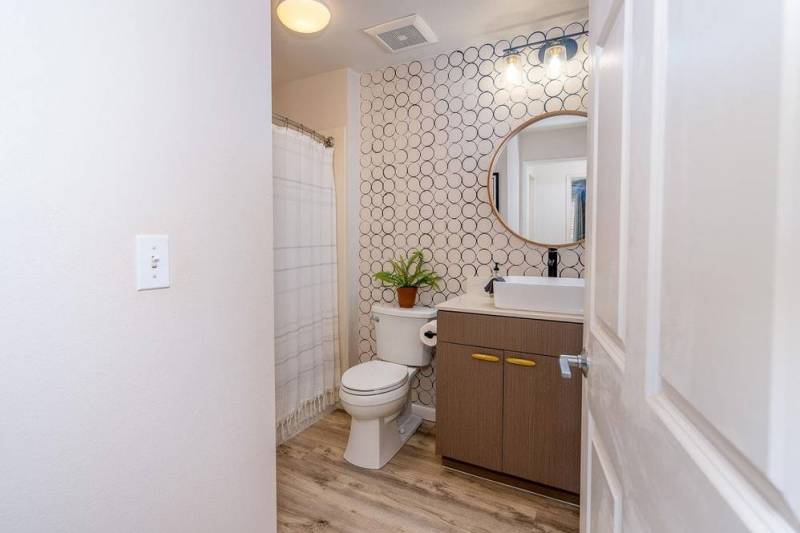 full bathroom with subtle geometric wallpaper