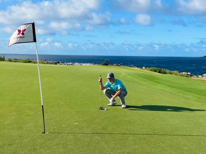 golfer looks at putt on kapalua bay golf course maui