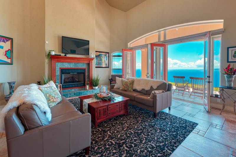living room with doors open to balcony with ocean views