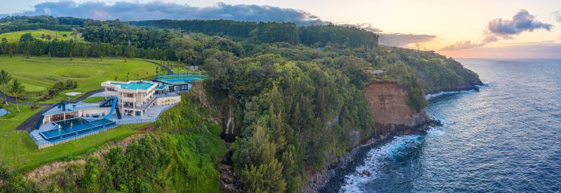 aerial view of cliffside estate on hawaii island with private waterfalling
