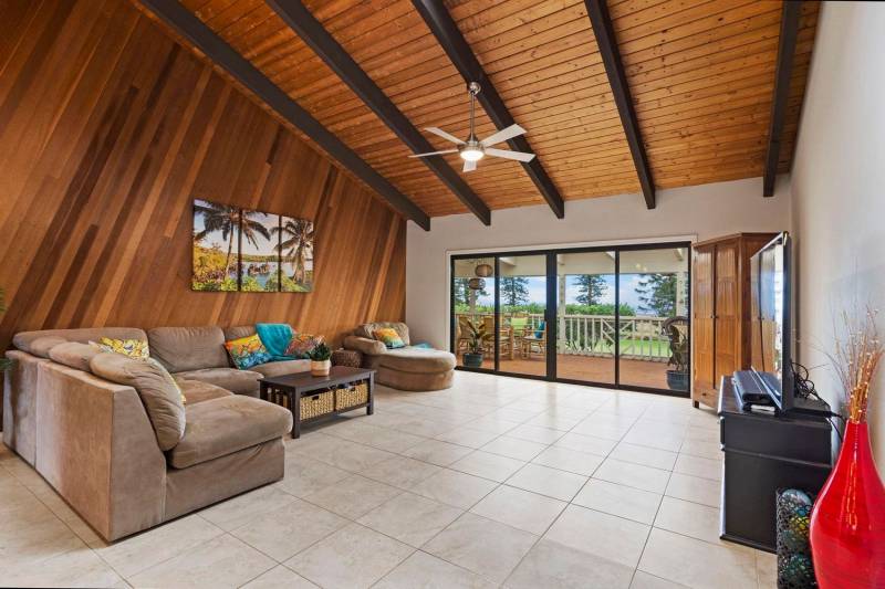 vaulted wood ceilings in living room with views through glass doors to backyard