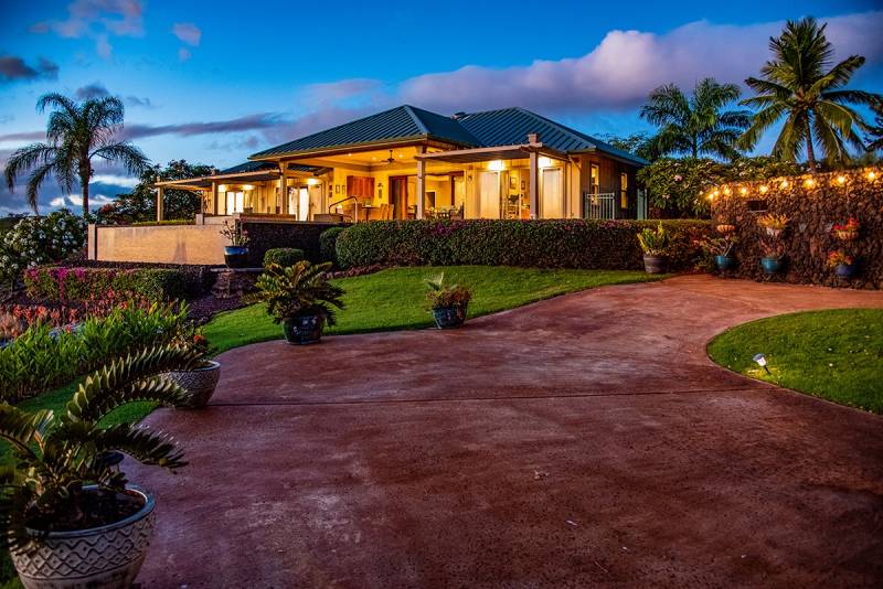driveway leading up to warmly lit Kohala Ranch house for sale Big Island, Hawaii at suset