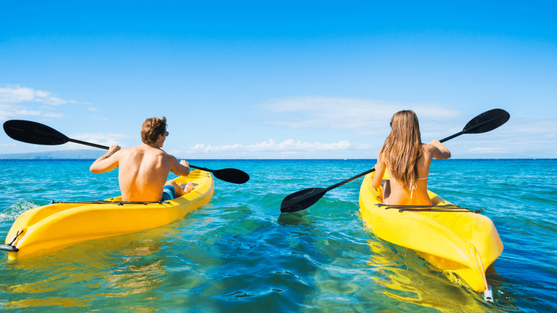 couple goes canoeing in hawaii ocean