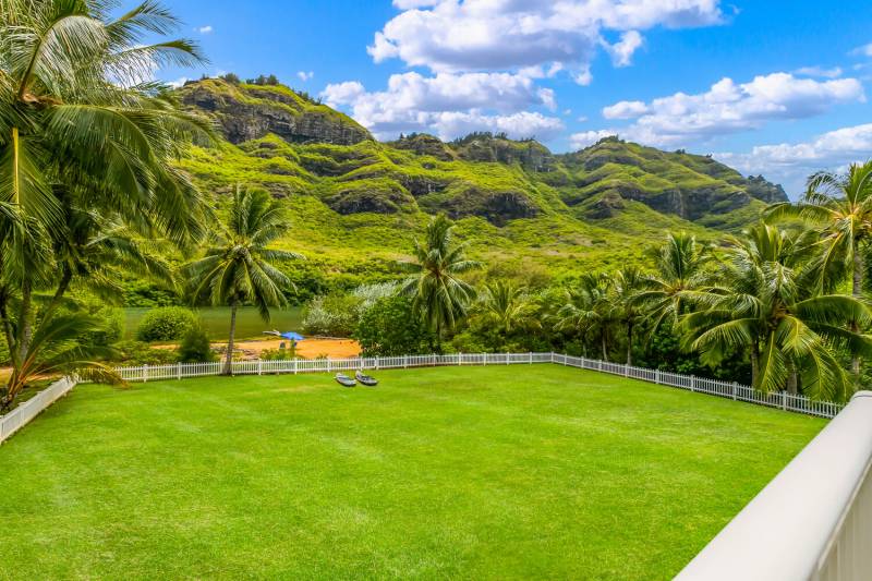 large grassy backyard and lush mountain views from kauai home