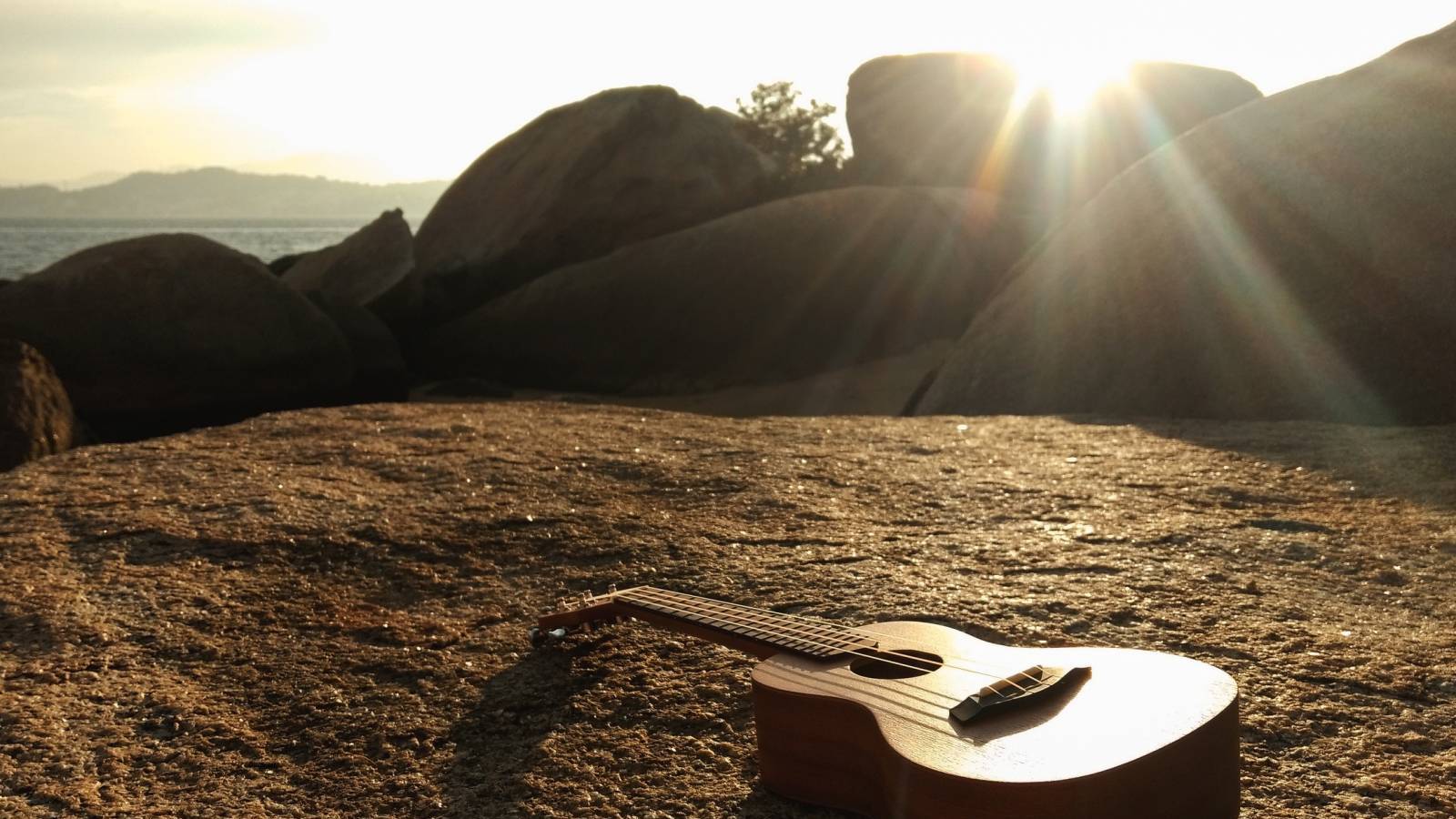 guitar on a rock in the sunshine