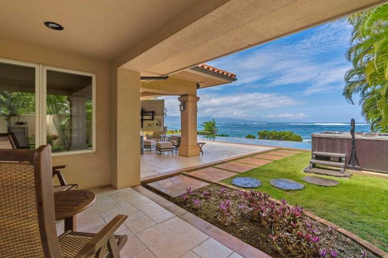 chairs sit on the lanai outside the back of the house look at ocean views