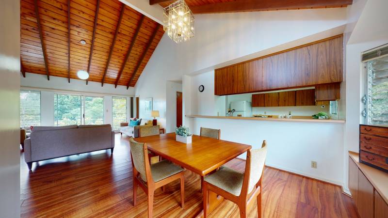 kitchen and dining area with warm wood floors, cabinets and ceiling