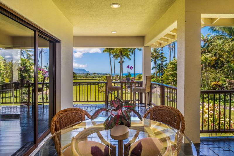 table and chairs on outdoor lanai with mountain and ocean views in background