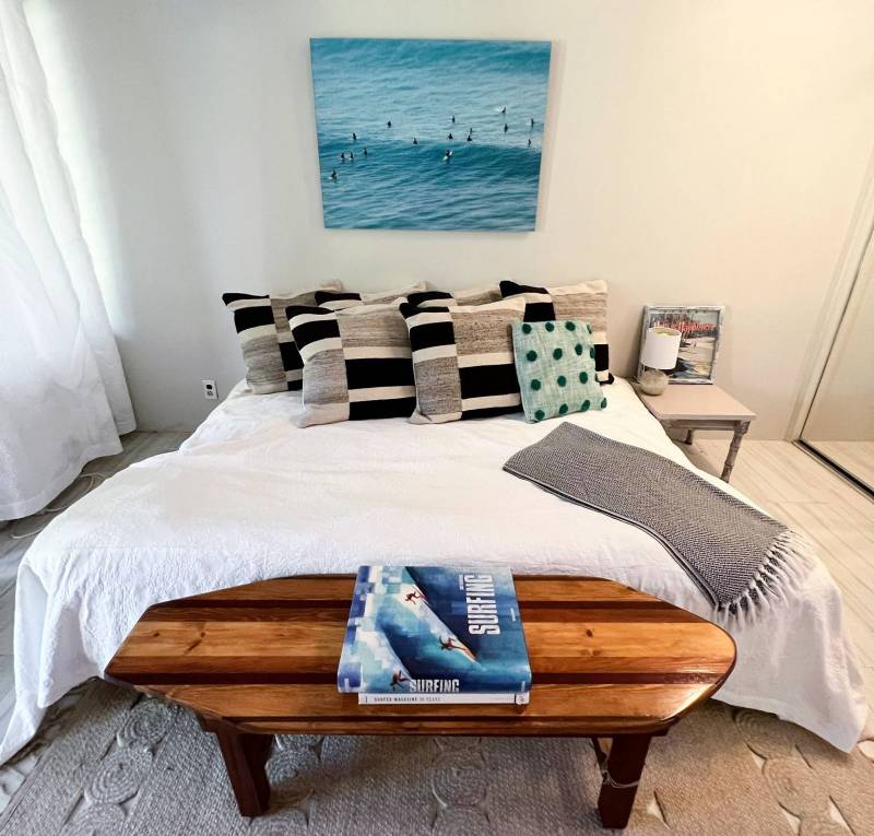 photo of surfers floating on waves hanging above bed