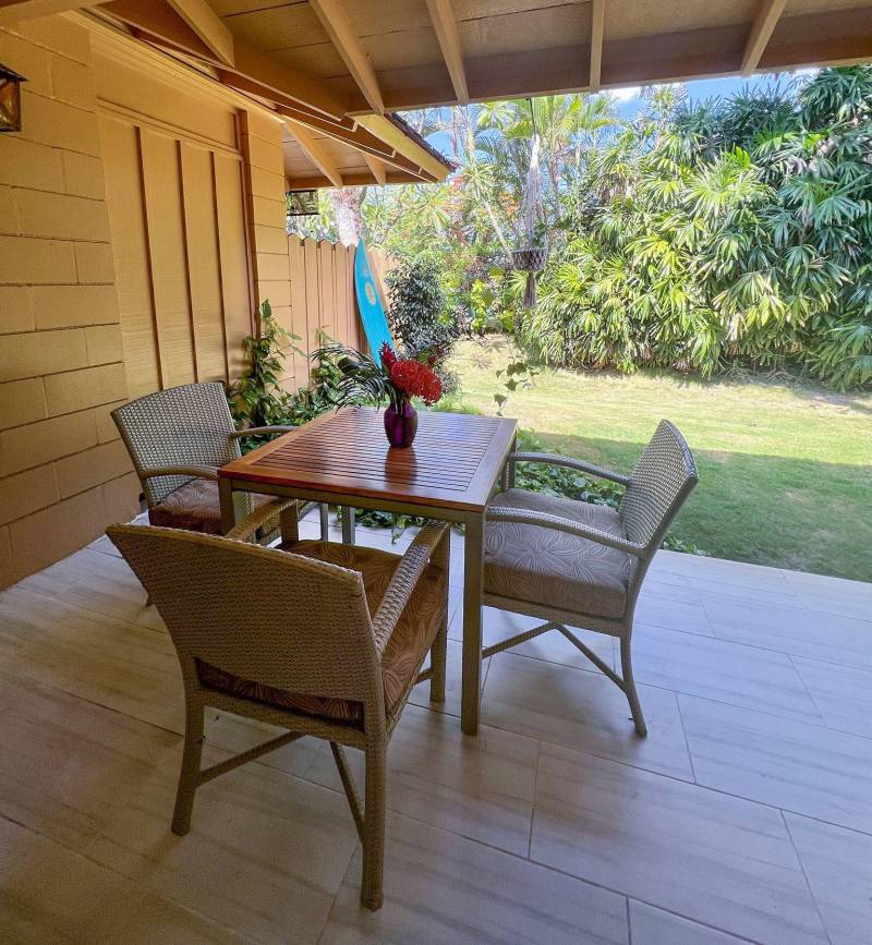 table and chairs on covered lanai in backyard of puamana condo for sale