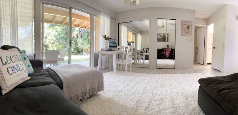 carpeted room with sofa and mirrored closet doors