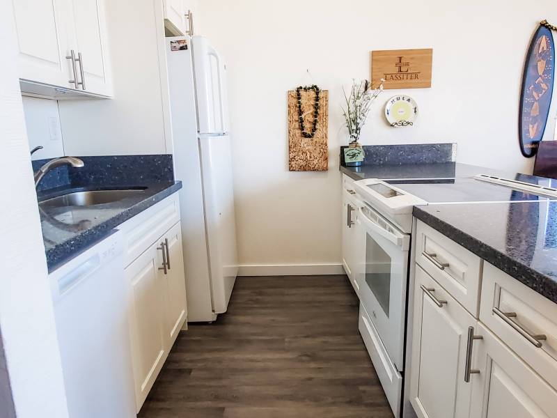 kitchen with white appliances and dark quartz countertops