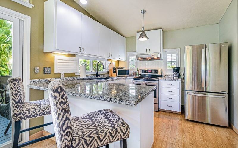 bright kitchen with white cabinets and stainless steel appliances