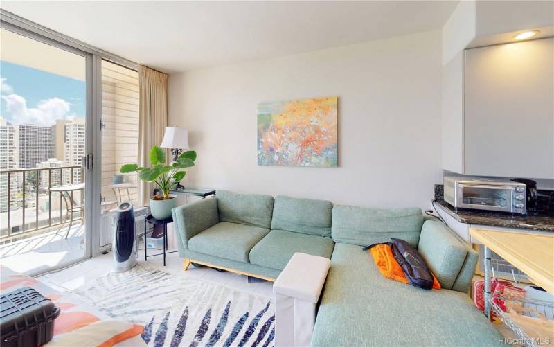 living room with low aqua blue sofa and sliding glass door with city views