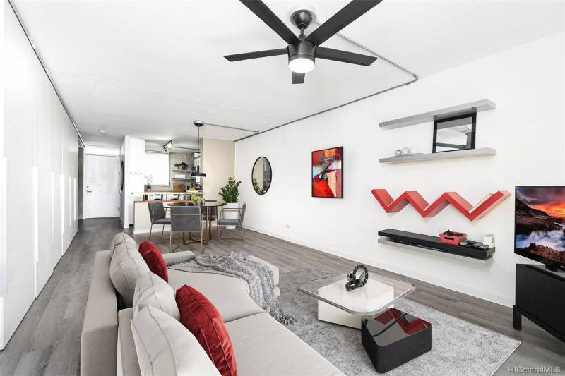 interior living room with gray floors and furniture with red accents