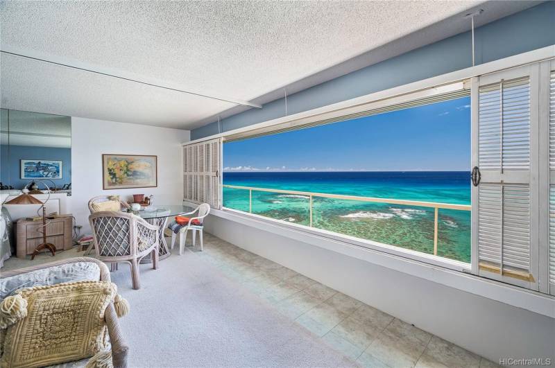 condo living area with large windows that open to big ocean views
