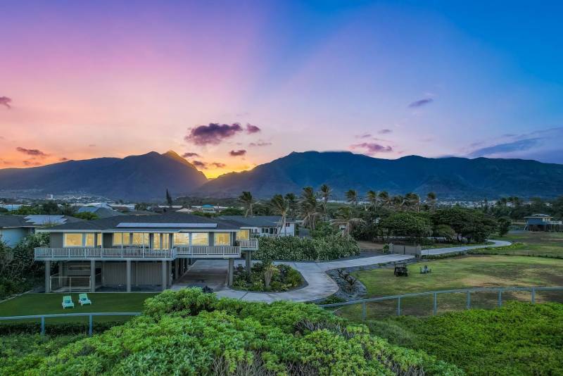 pink and purple sky during sunrise between mountains behind luxury home