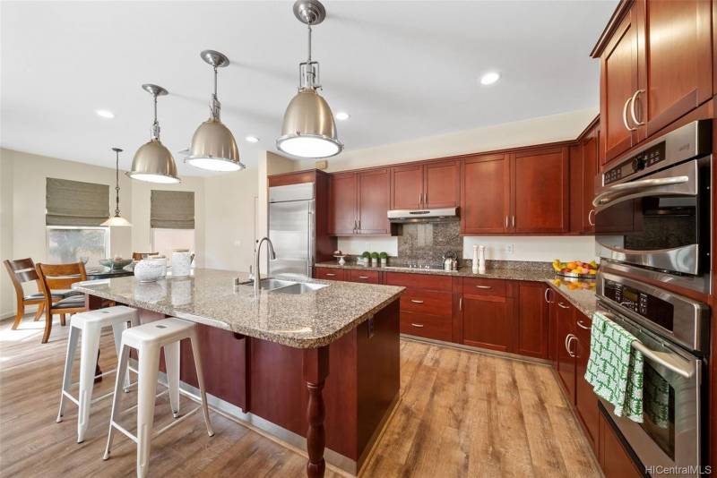 large open concept kitchen with stainless steel appliance and barstools at the island