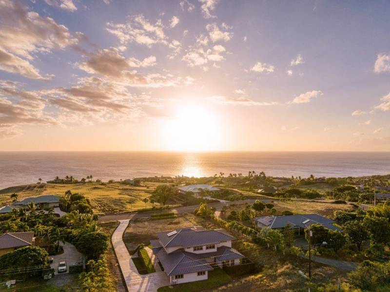 aerial view of kohala by the sea home and sunset over the ocean