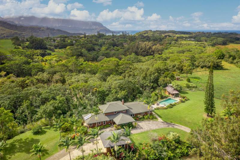 drone view of kauai estate with pool and outbuildings situated amongst lush tropical plants