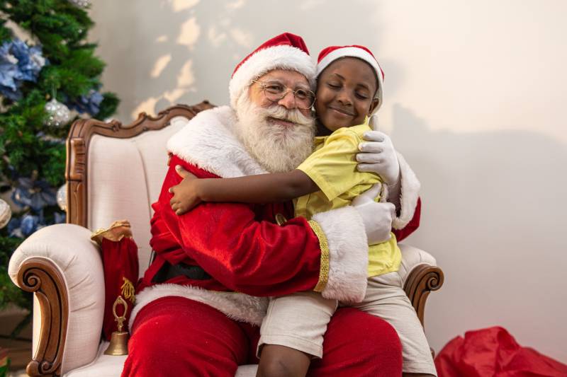 child sitting on santa's lap hugging
