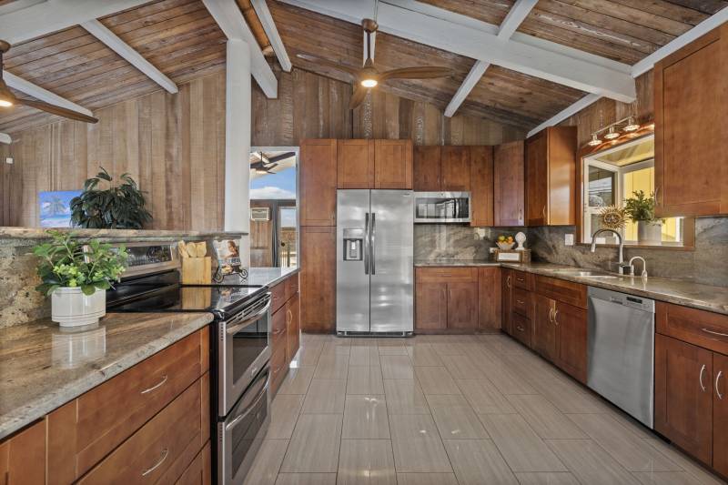 beautiful kitchen with warm wood cabinets and redwood walls and ceiling