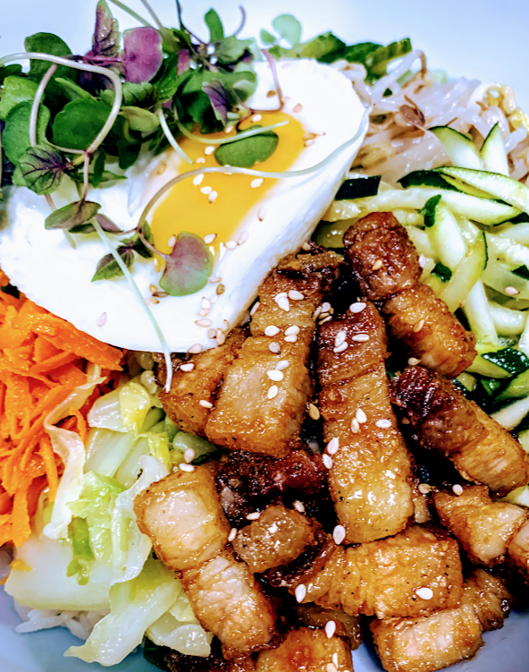 korean bibimbap with egg and microgreens on top