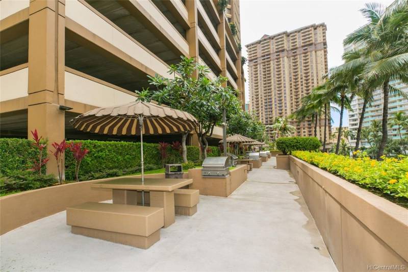 communal bbq and tables with umbrellas at honolulu condo