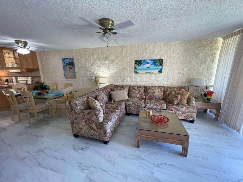 maui condo living room with marble floors and cream colored brick wall