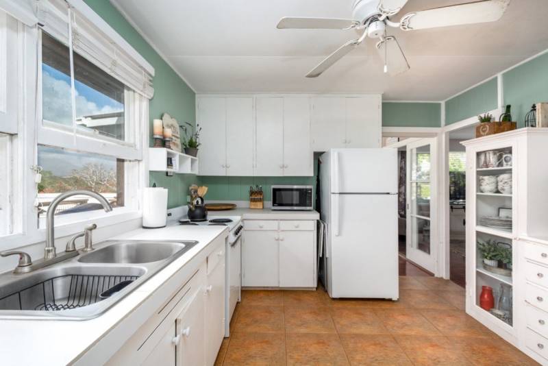 white cabinets, white countertops and white appliances in kitchen