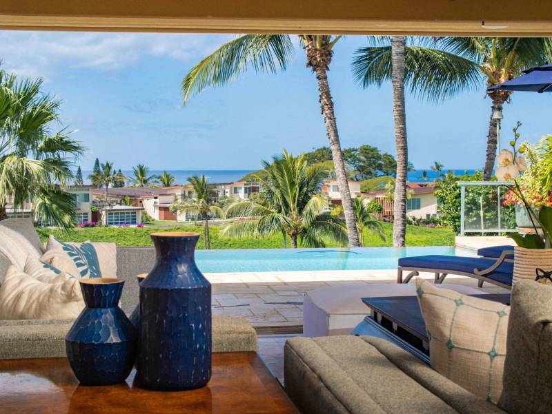 seating on covered lanai with view to pool and ocean