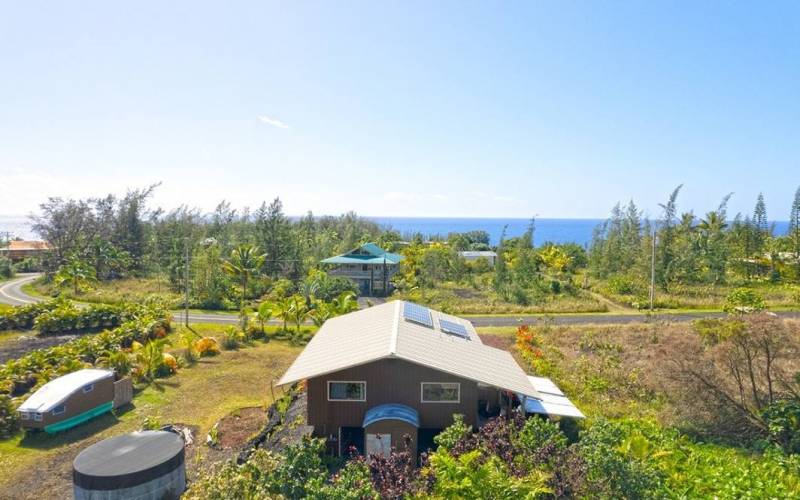 aerial view of big island off grid home and tiny home with ocean in background