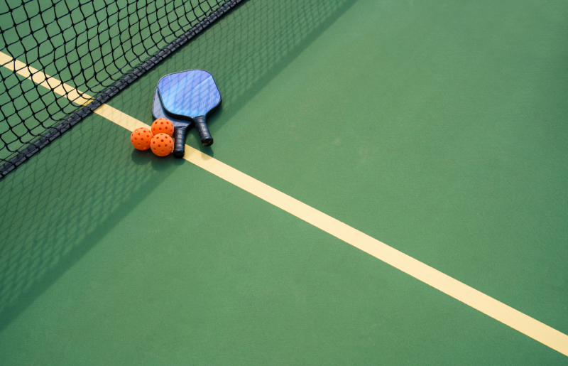 pickleball court with paddles and balls