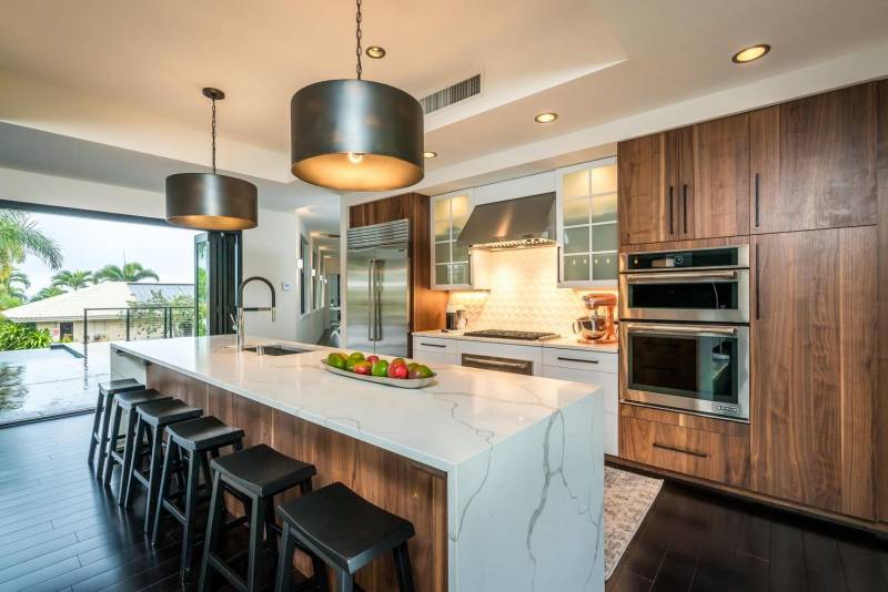 modern kitchen with large island and six barstools for seating