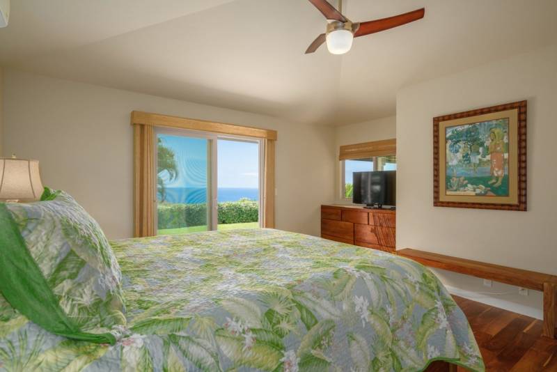bedroom with sliding glass door that lets in blue ocean view