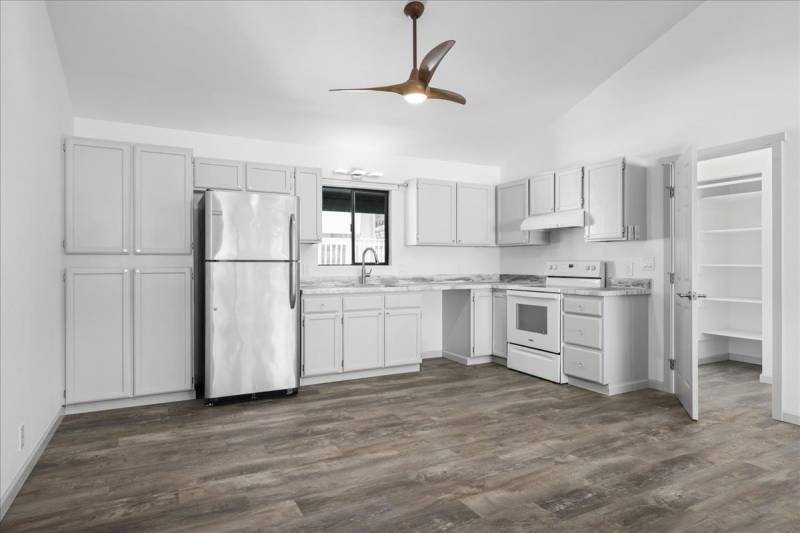 newly renovated kitchen with white cabinets and gray vinyl plank floors