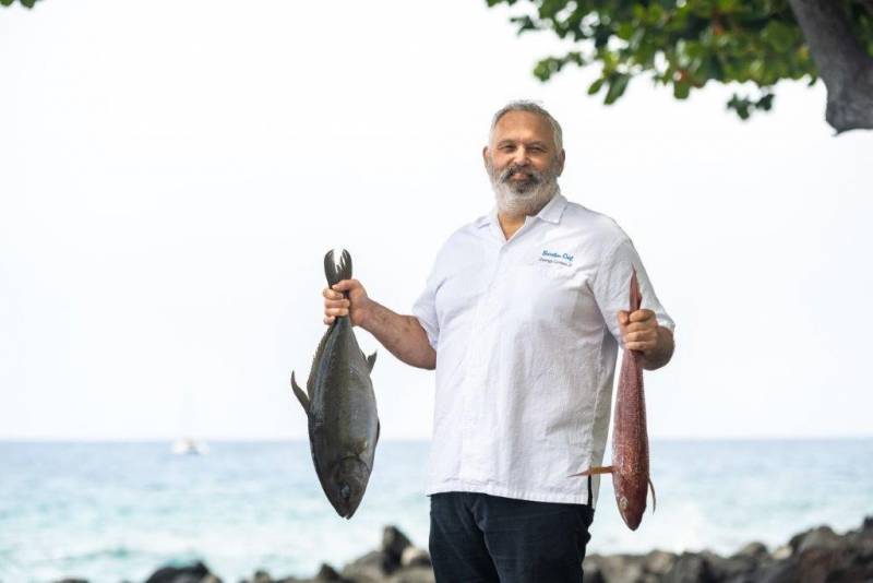 chef holding a fish in each hand