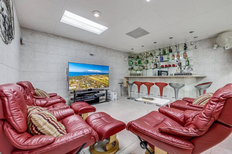 red leather chairs around tv in bar area
