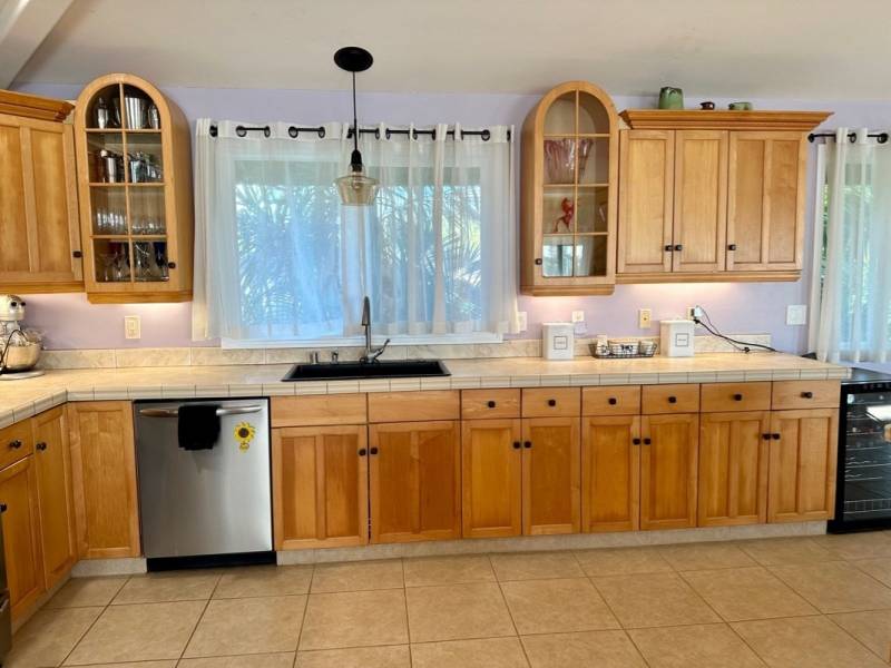 beige ceramic tile and light wood cabinets in the kitchen