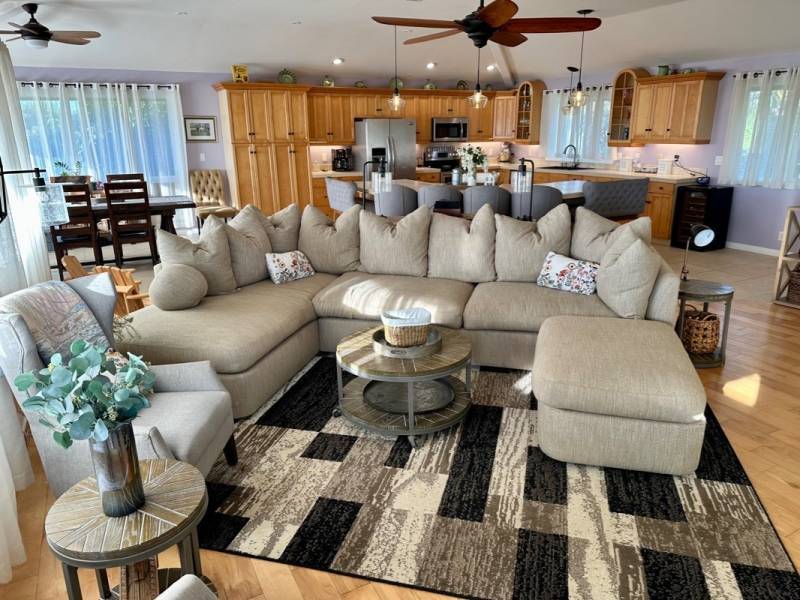 beige sectional on multi toned rug in great room