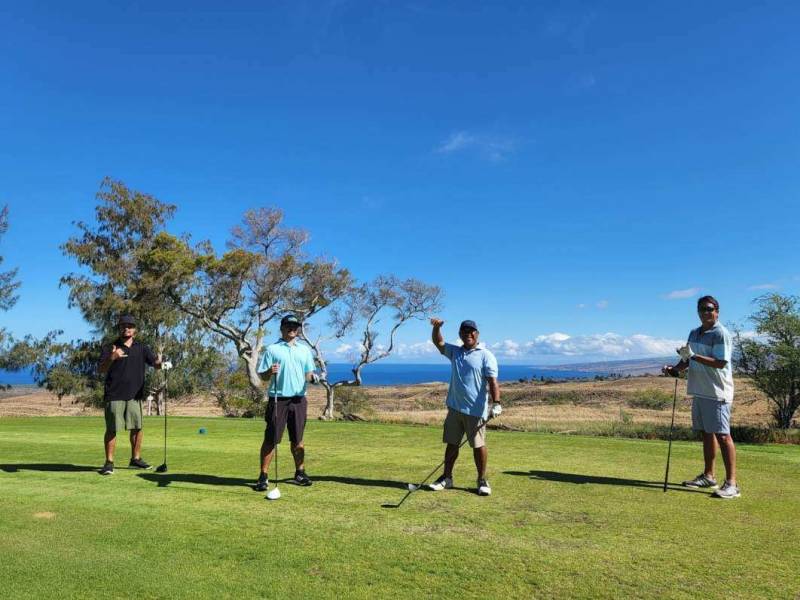 four men playing golf on waikoloa village golf course