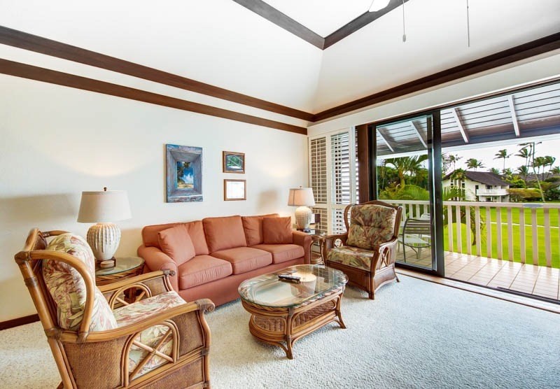 kauai condo living room with white carpet and sliding glass door to lanai