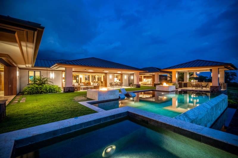 luxury hokulia home and pool lit up at night