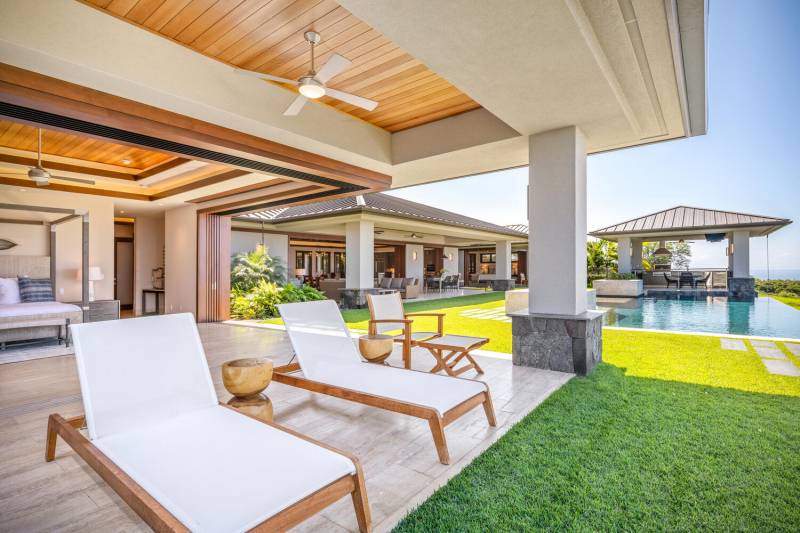 lounge chairs under covered lanai near pool