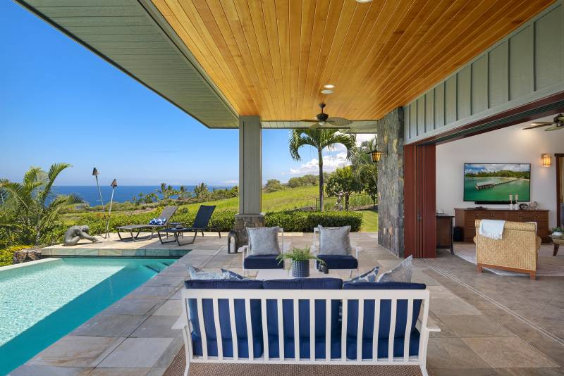 comfortable outdoor seating near the pool at luxury hokulia hawaii residence